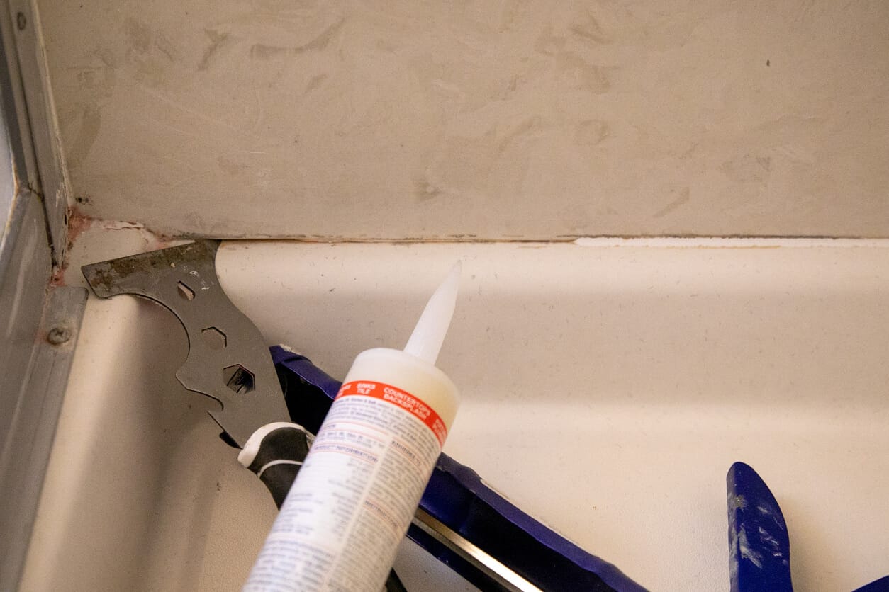 Bathroom ceiling exhaust fan vent above a tiled shower